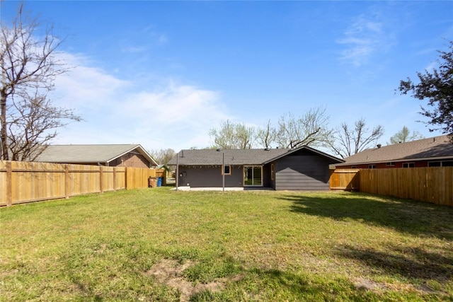 back of property featuring a yard and a fenced backyard