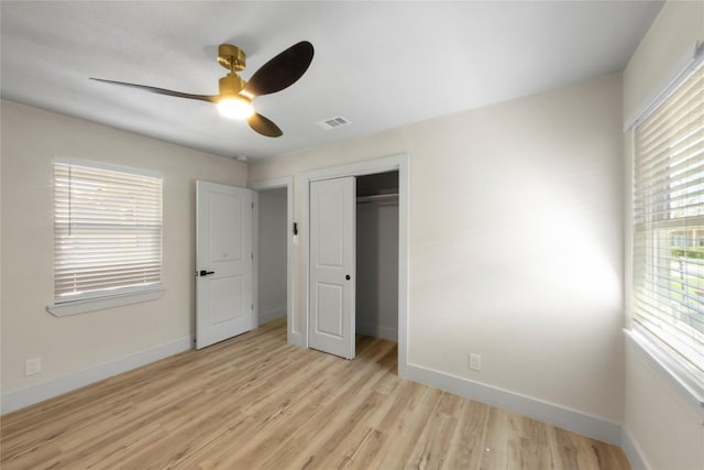 unfurnished bedroom with visible vents, ceiling fan, baseboards, light wood-type flooring, and a closet