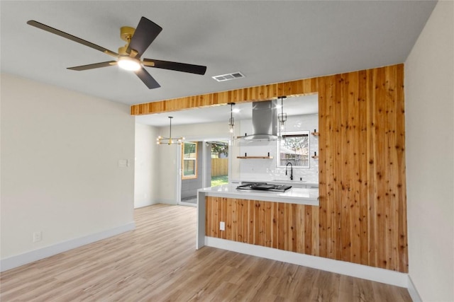 kitchen featuring ventilation hood, visible vents, light wood finished floors, a sink, and stainless steel gas stovetop