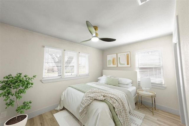 bedroom featuring wood finished floors, baseboards, and ceiling fan