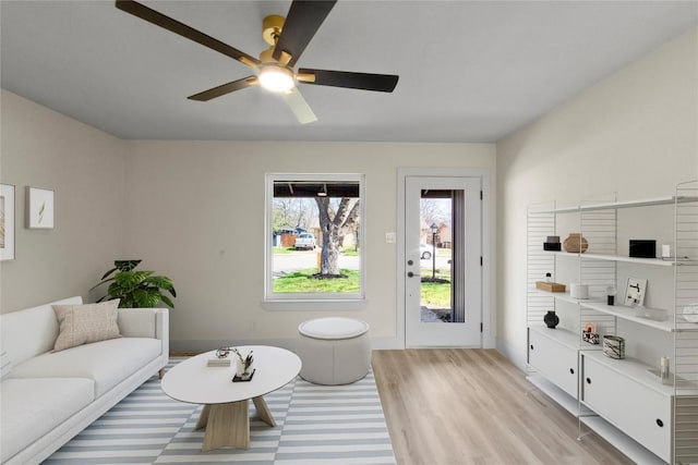 living room with light wood-type flooring and a ceiling fan