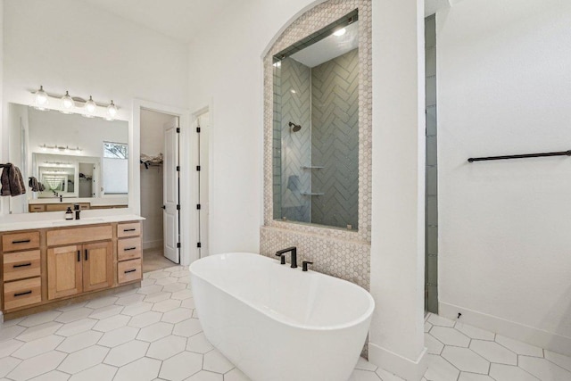 full bath with tile patterned flooring, tiled shower, vanity, and a freestanding tub