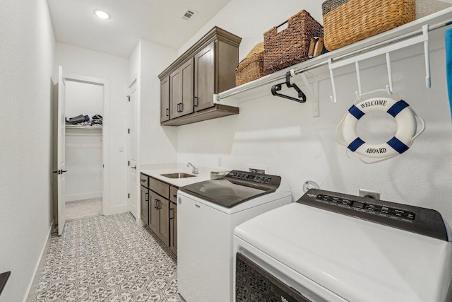 laundry room featuring visible vents, baseboards, washer and dryer, cabinet space, and a sink