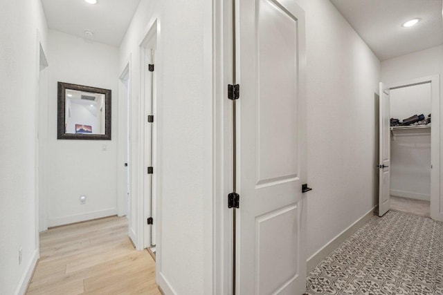 hallway featuring recessed lighting, light wood-style floors, and baseboards