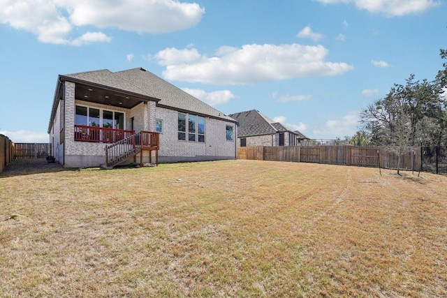 rear view of property with stairway, a fenced backyard, and a lawn