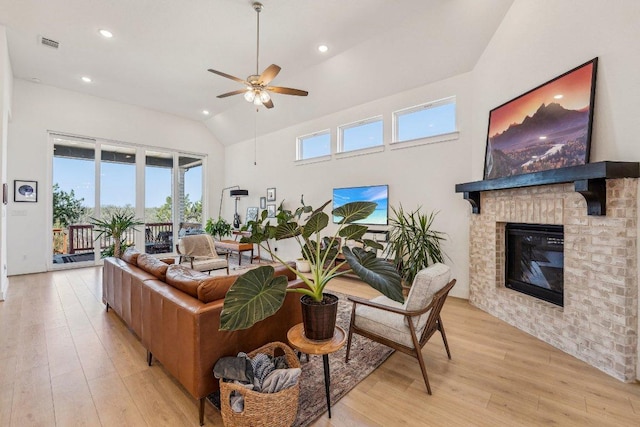 living area with light wood finished floors, recessed lighting, a brick fireplace, and ceiling fan