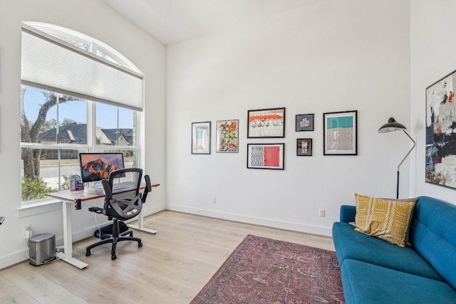 office space with wood finished floors, a healthy amount of sunlight, and baseboards