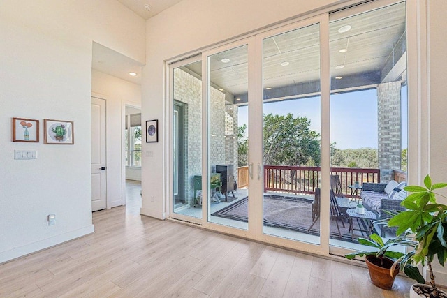 doorway to outside with recessed lighting, baseboards, and wood finished floors