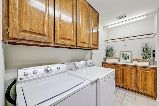 410 Rolling Green Dr, Lakeway, TX 78734 - laundry room featuring washer and dryer, cabinet space, and light tile patterned flooring