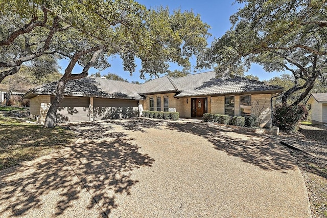 single story home featuring a garage, driveway, and a tile roof