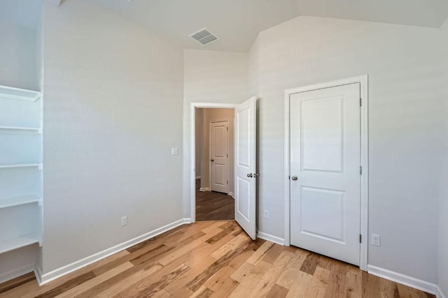 107 Lemuel Crawford Trl, Bastrop, TX 78602 - unfurnished bedroom featuring light wood-style flooring, lofted ceiling, and baseboards