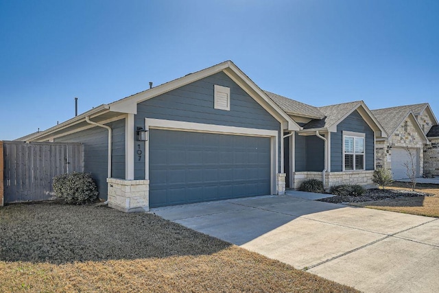 107 Lemuel Crawford Trl, Bastrop, TX 78602 - ranch-style home featuring stone siding, a garage, and driveway