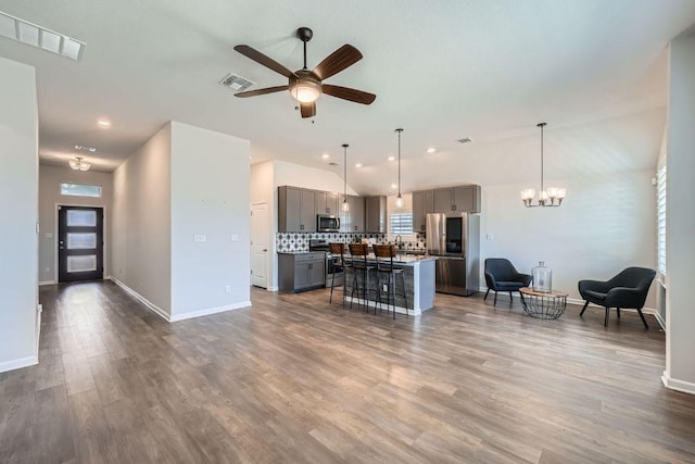 107 Lemuel Crawford Trl, Bastrop, TX 78602 - living area featuring a ceiling fan, a chandelier, dark wood-style floors, vaulted ceiling, and recessed lighting