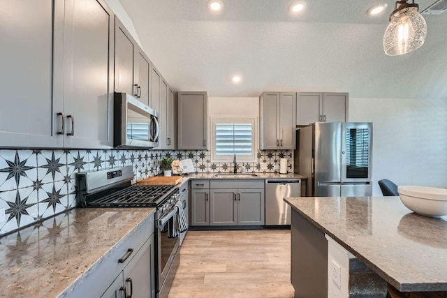 107 Lemuel Crawford Trl, Bastrop, TX 78602 - kitchen featuring stainless steel appliances, gray cabinetry, light stone counters, tasteful backsplash, and recessed lighting