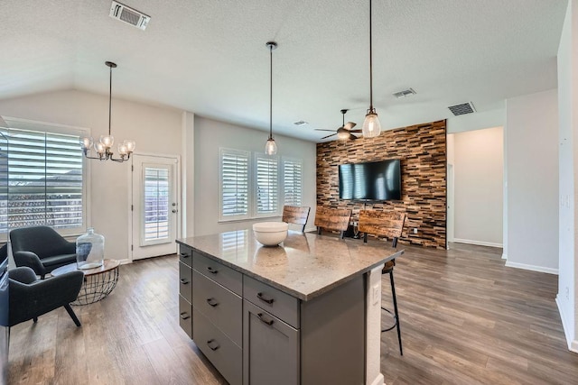 107 Lemuel Crawford Trl, Bastrop, TX 78602 - kitchen with gray cabinetry, a ceiling fan, open floor plan, wood finished floors, and a kitchen island