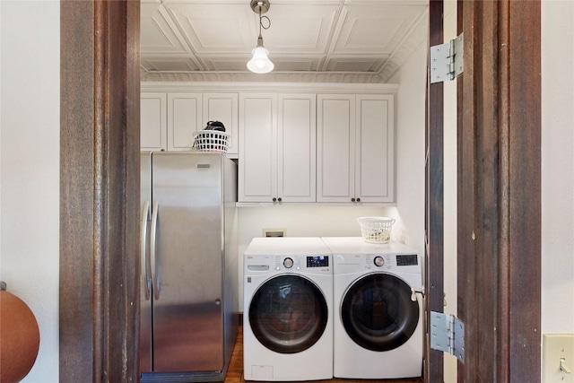 laundry room featuring cabinet space, washing machine and dryer, and an ornate ceiling