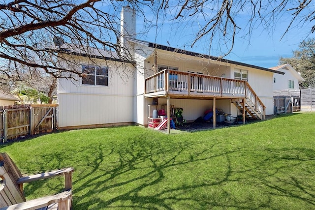 back of property featuring a deck, stairway, a lawn, and a fenced backyard