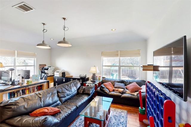 living room with recessed lighting, visible vents, and wood finished floors