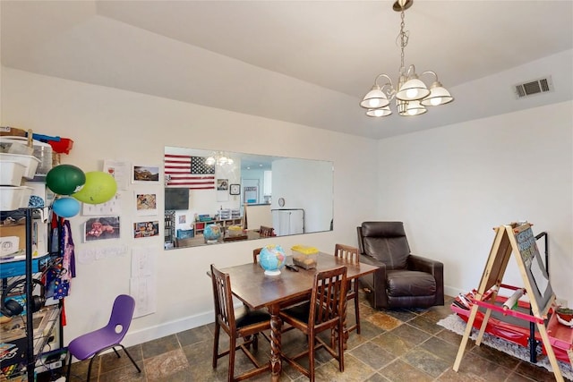 dining space featuring visible vents, baseboards, stone finish flooring, and an inviting chandelier