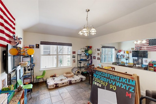 rec room with a chandelier, plenty of natural light, and stone finish flooring