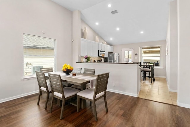 dining room featuring wood finished floors, visible vents, and a wealth of natural light