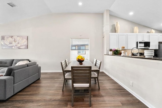 dining area with vaulted ceiling, visible vents, baseboards, and dark wood-style flooring