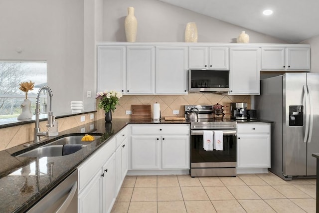 kitchen with a sink, stainless steel appliances, lofted ceiling, and white cabinets