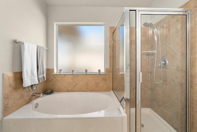 full bathroom featuring a shower stall and a garden tub