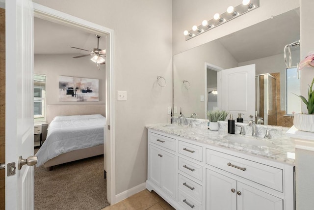 bathroom with a sink, connected bathroom, a shower stall, tile patterned flooring, and vaulted ceiling