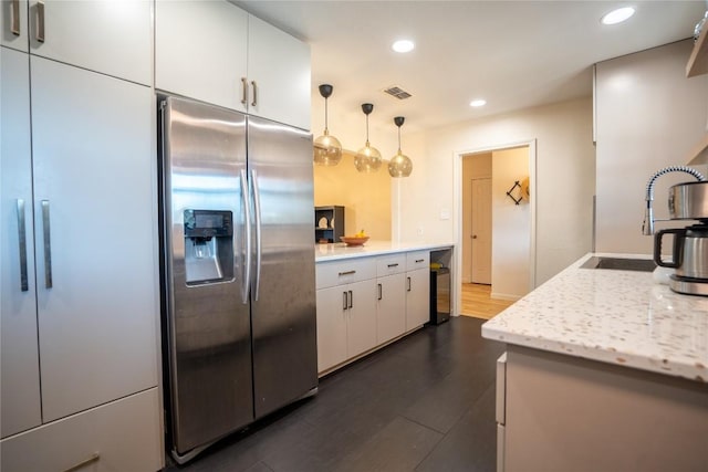 kitchen featuring visible vents, dark wood finished floors, recessed lighting, stainless steel refrigerator with ice dispenser, and white cabinets