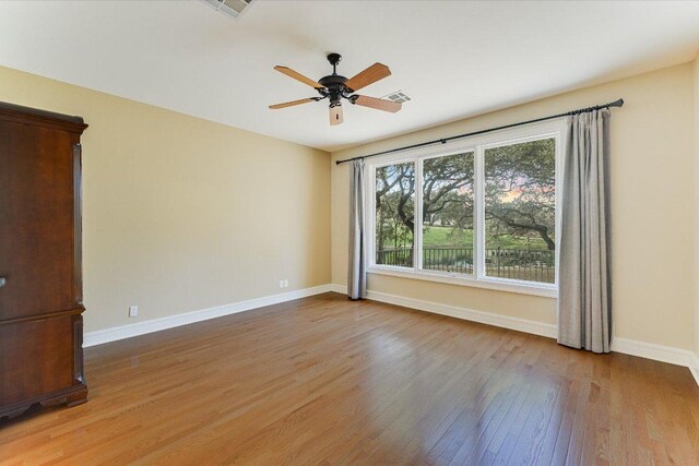 unfurnished room with a ceiling fan, baseboards, visible vents, and light wood finished floors