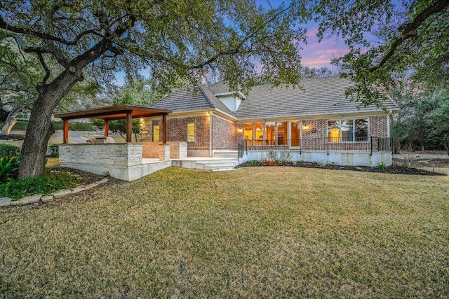 view of front of house featuring brick siding and a front lawn