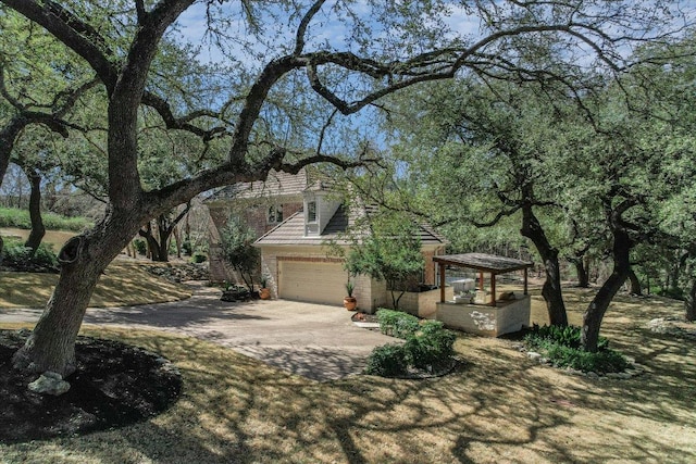 view of front of property featuring brick siding, driveway, and an attached garage