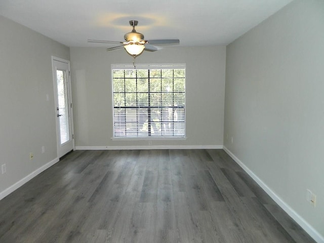 unfurnished room featuring ceiling fan, baseboards, and dark wood finished floors