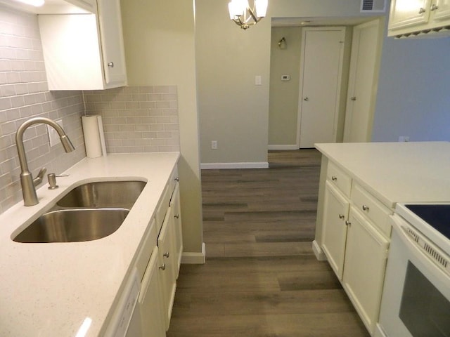 kitchen with white cabinetry, dark wood-type flooring, tasteful backsplash, and a sink