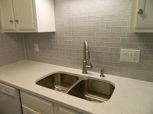 details featuring backsplash, dishwasher, light stone countertops, and a sink