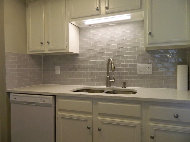 kitchen featuring a sink, light countertops, decorative backsplash, and white dishwasher