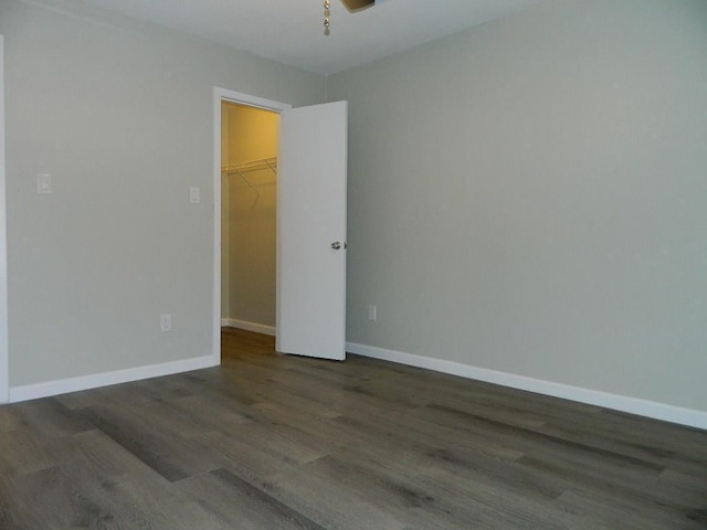 empty room featuring ceiling fan, baseboards, and wood finished floors