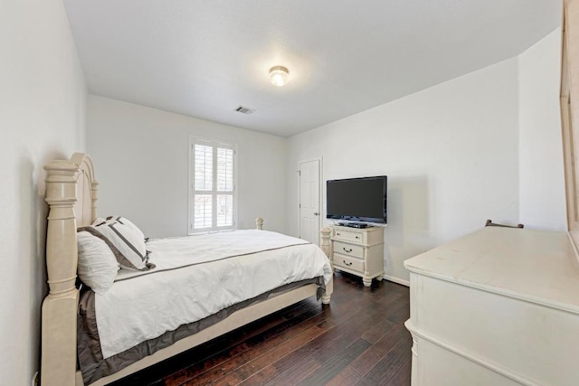 bedroom with dark wood-style floors and visible vents