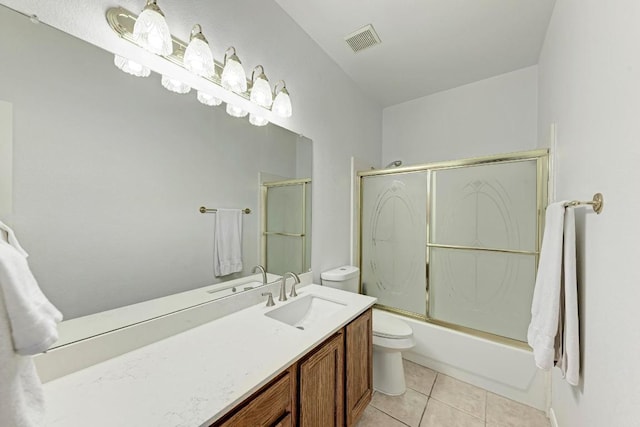 full bathroom featuring tile patterned floors, visible vents, toilet, shower / bath combination with glass door, and vanity