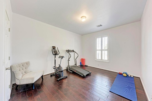 workout room with baseboards, visible vents, and wood-type flooring