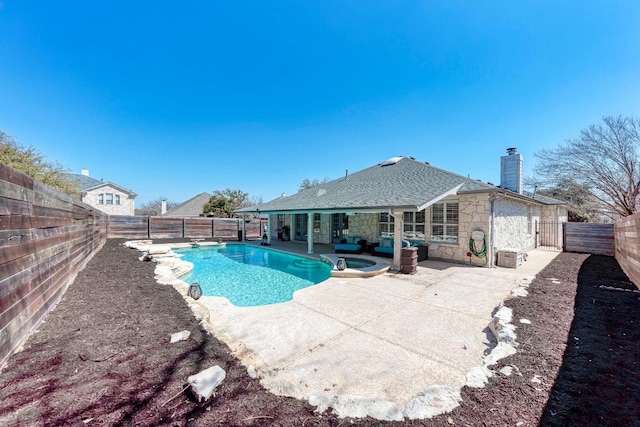 view of pool with a pool with connected hot tub, a fenced backyard, and a patio area