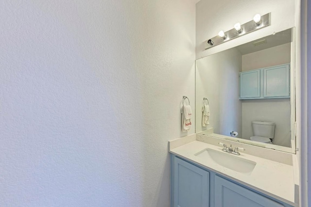 1000 Rutgers Dr, Pflugerville, TX 78660 - bathroom featuring toilet, a textured wall, and vanity