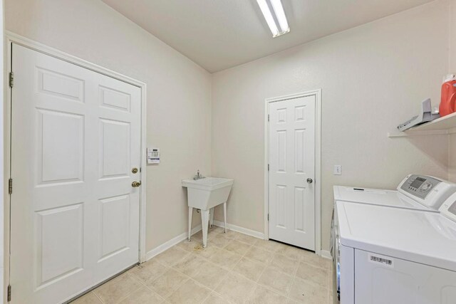 laundry area with laundry area, separate washer and dryer, and baseboards