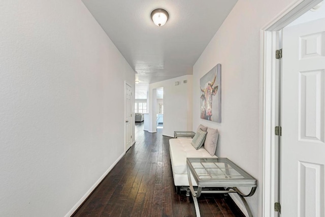 hallway with dark wood finished floors and baseboards