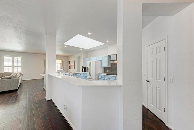 kitchen with dark wood-style floors, open floor plan, a skylight, and white refrigerator with ice dispenser