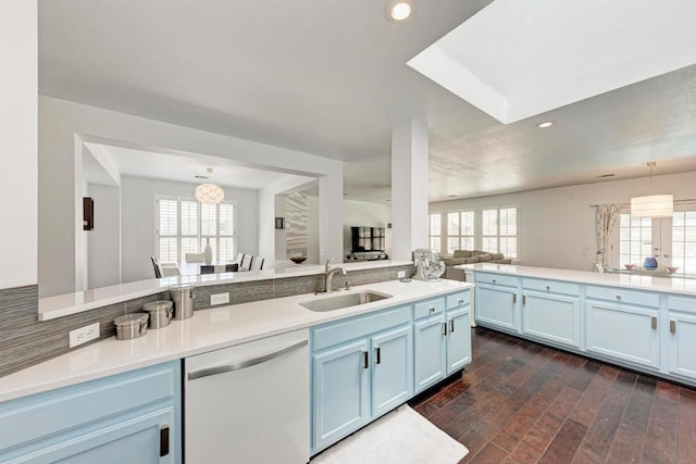 kitchen featuring open floor plan, plenty of natural light, white dishwasher, and a sink