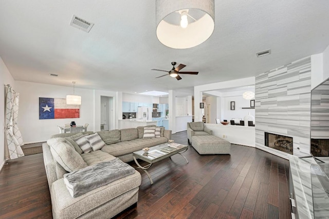 1000 Rutgers Dr, Pflugerville, TX 78660 - living area featuring dark wood-style flooring, ceiling fan, and a tiled fireplace