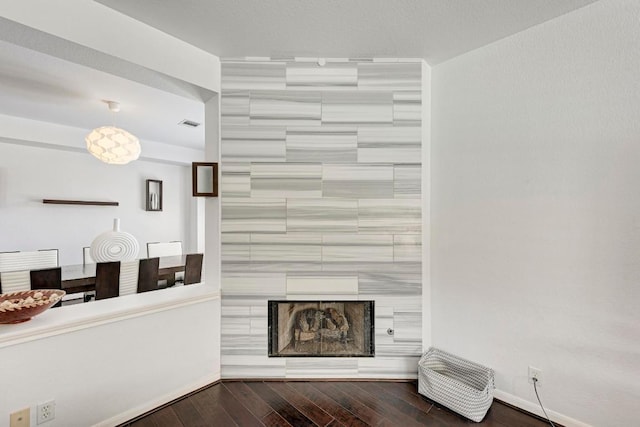 living area featuring visible vents, baseboards, and wood-type flooring