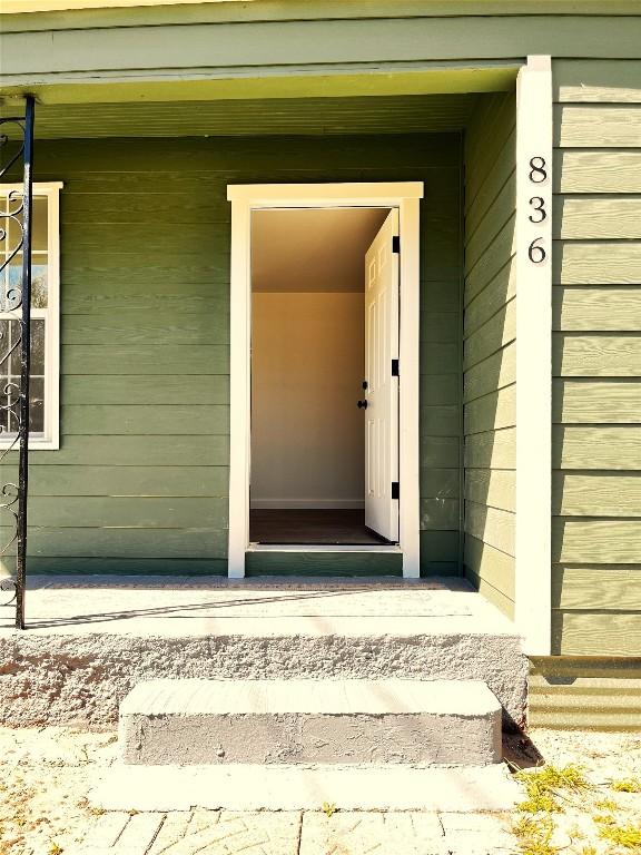 view of exterior entry with a porch